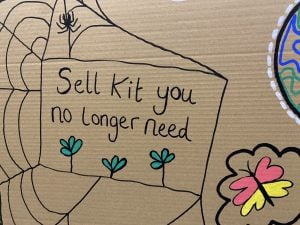 A cardboard sign at a convention with the words 'Sell kit you no longer need' on it