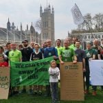 A group of green runners in front of Big Ben in London campaigning for greater action of the climate emergency. They are holding banners reading 'We can't run away from this'