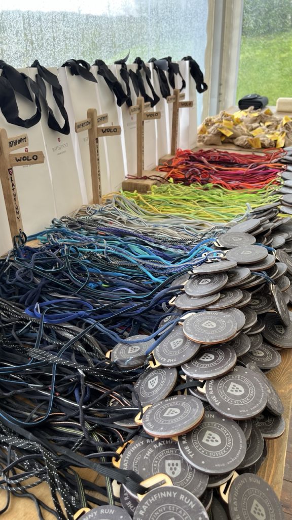 A large pile of handmade medals strung with old shoe laces, allowing them to be made sustainably