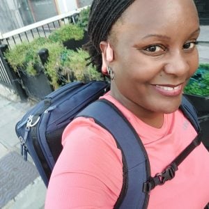 Tasha Thomspon of Black Girls Do Run wearing a rucksack and a pink top as she run commutes to work