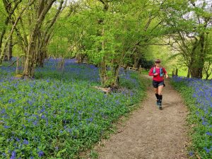Shirin Shabestari running in a woodland with a carpet of bluebells